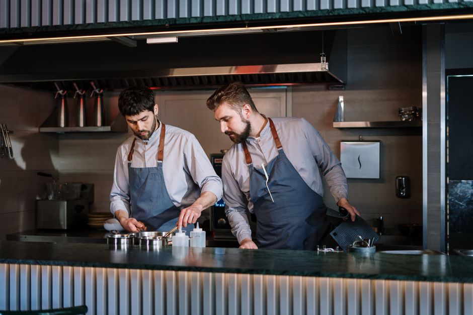 Professional restaurant kitchen with chef preparing food at an open counter